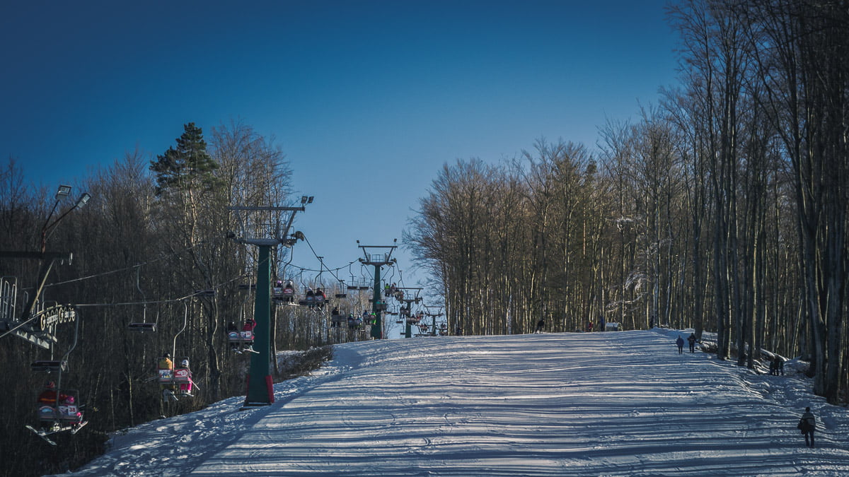 Văliug ski slope in winter with tourists.