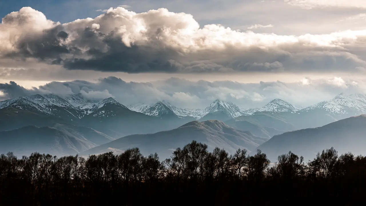 The Retezat Mountains with snow on their peaks.