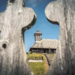 The Wooden Church of the Holy Apostles Peter and Paul between the fence.