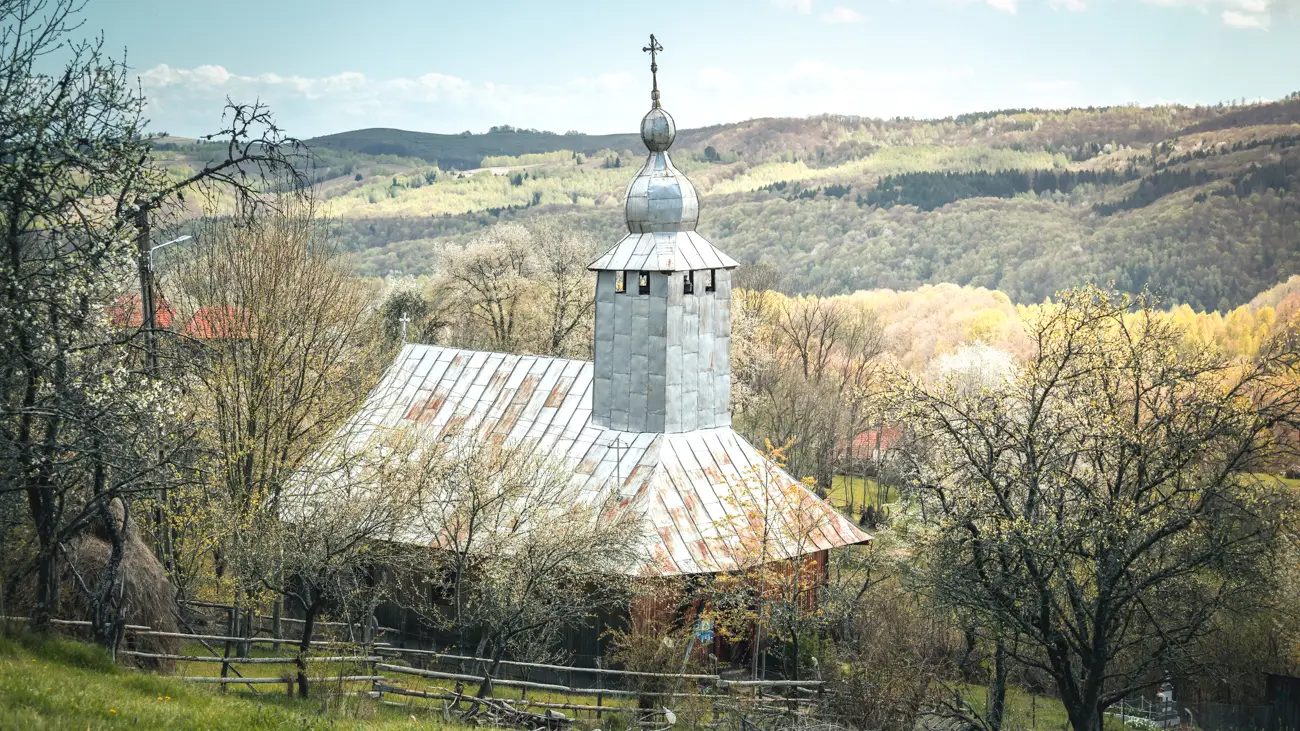 The church with the forested hills in the background.