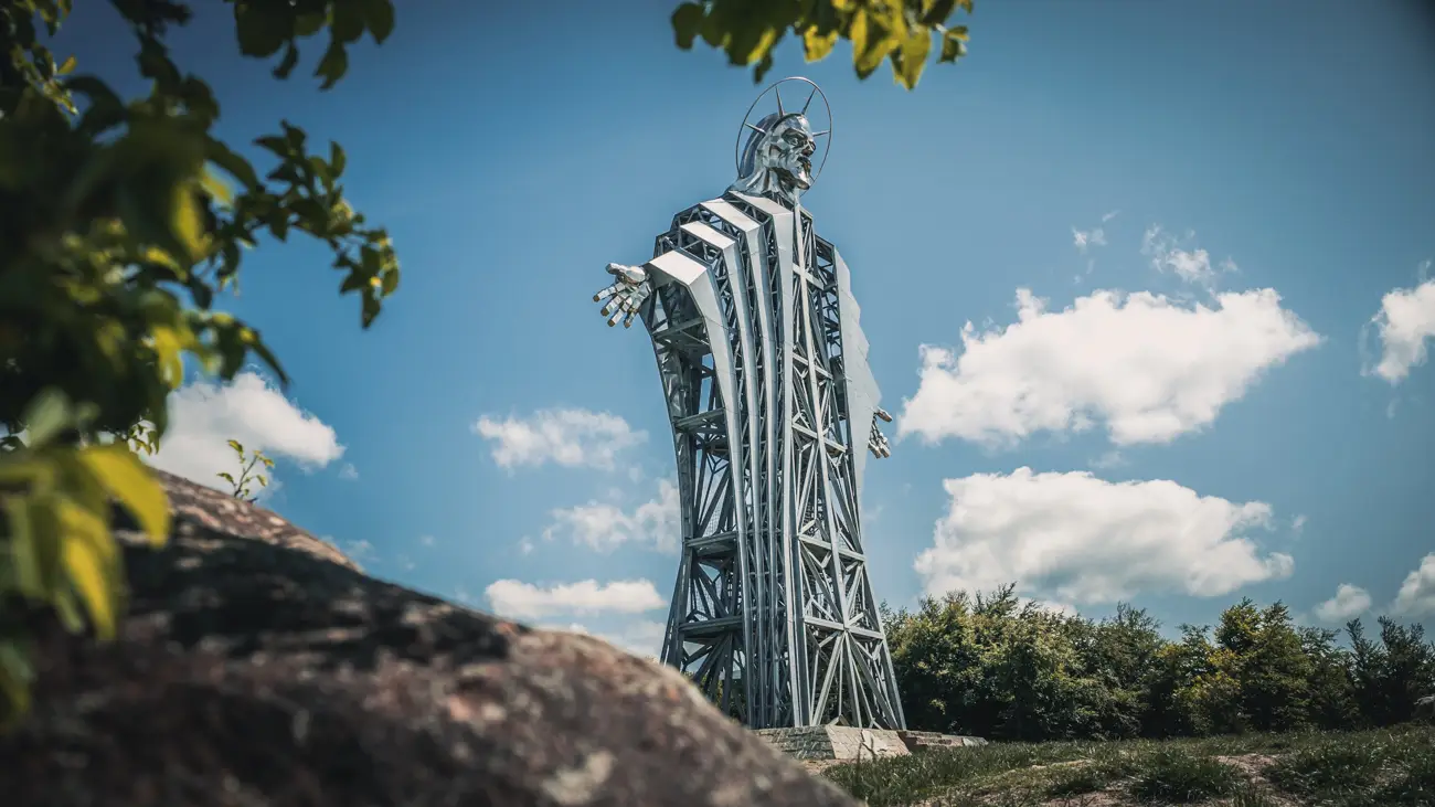 Next to the tall statue.